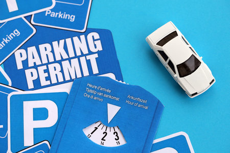 Parking permit paper notice tag and parking disc with toy car. Parking permit for people with disabilities conceptの写真素材
