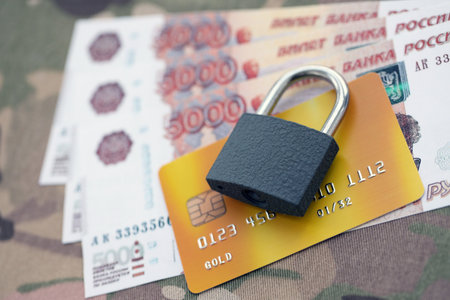 Russian rubles money bills and credit card under ban of heavy lockpad close up. Concept of sanctions and restrictions to russian citizensの写真素材