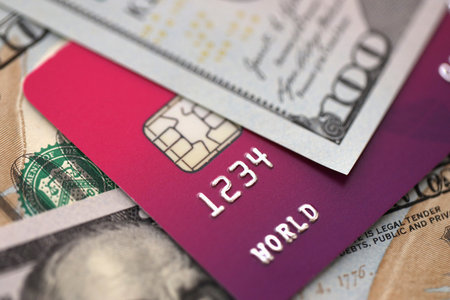 One hundred US dollar bill banknote on purple credit card for banking and payments. Concept of business and bank serviceの写真素材