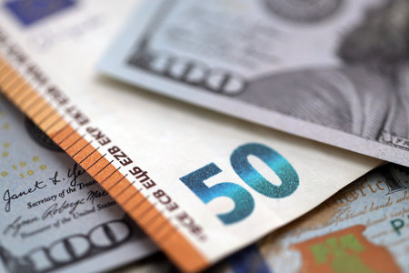 One hundred US dollar bill banknotes and fifty european Euro currency banknote. Concept of currency exchange between USD and EURの写真素材