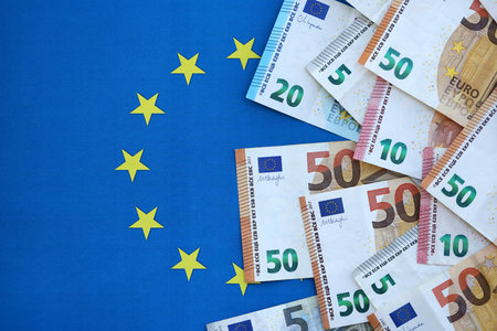 Many euro money bills banknotes on flag of European Union. Concept of business and finances in Europeの写真素材