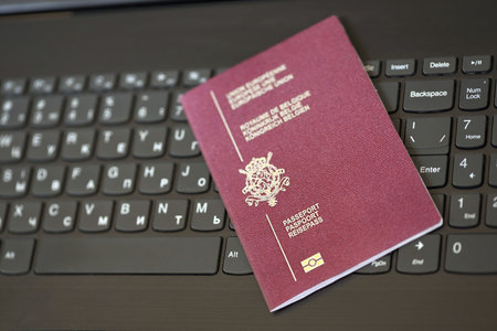 Belgium passport lies on black laptop keyboard buttons background close up. Technologies and control in Europe conceptの写真素材