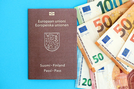Finland passport lies with euro money banknotes on blue background close up. Salary and pension in Europe conceptの写真素材