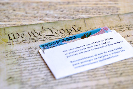 Permanent resident green card in envelope lies on US constitution page close upの写真素材
