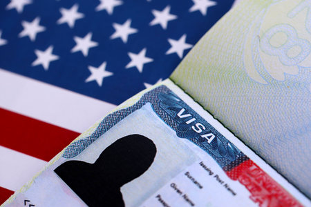 U.S. VISA United States of America. American Tourist or Green Card Visa on flag background close upの写真素材