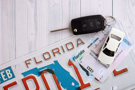 Remote control car keys on Florida license plate with driver license. Concept of driving in Florida. Reaching a driving permitの写真素材