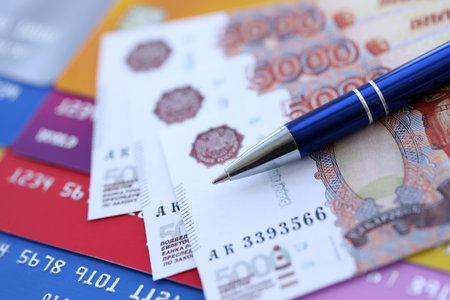 Credit cards and pen with Russian ruble currency money bills banknotes. Business, financial operations and accounting in Russian Federationの写真素材