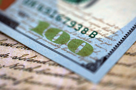 One hundred US dollar bills and United States Constitution page fragment. Concept of lawsuit in...