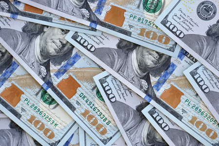 Many one hundred dollars money bills banknotes on smooth surface close up. Concept of business, rich...