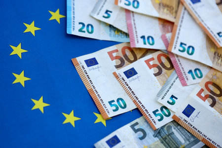 Many euro money bills banknotes on flag of European Union. Concept of business and finances in...