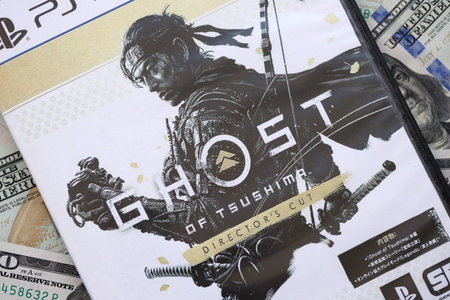 KYIV, UKRAINE - SEPTEMBER 8, 2025 Ghost of Tsushima videogame lies on big amount of hundred dollar...
