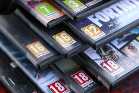 KYIV, UKRAINE - SEPTEMBER 8, 2025 PEGI game rating on a stack of PlayStation5 videogames close up. Pan European Game Informationのeditorial素材