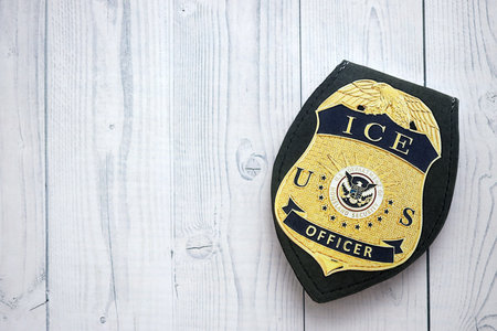 KYIV, UKRAINE - SEPTEMBER 17, 2025 US ICE Officer badge on white wooden table surface close upのeditorial素材