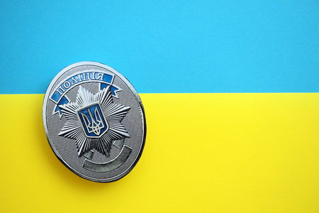 KYIV, UKRAINE - SEPTEMBER 17, 2025 Ukrainian Police badge on Ukrainian national flag surface close upのeditorial素材