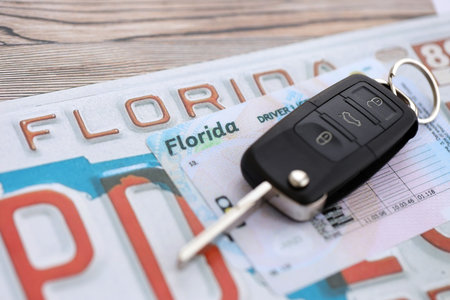 Remote control car keys on Florida license plate with driver license. Concept of driving in Florida. Reaching a driving permitの写真素材
