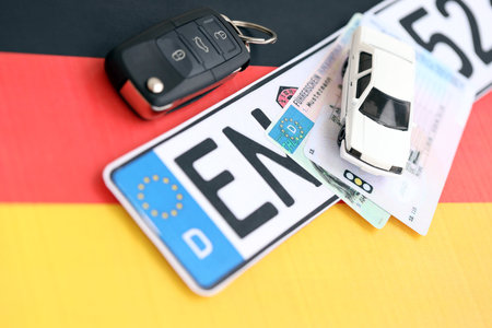 Germany Deutschland car license plate and ignition key on german flag close up. Driving permit and registration conceptの写真素材