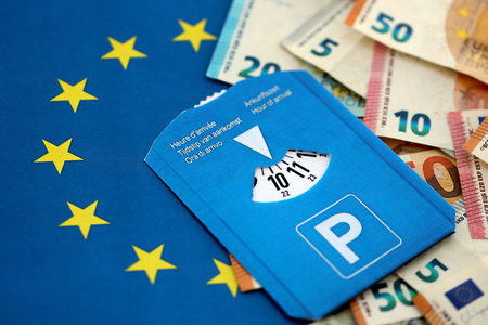 European parking disc with time dial on many euro money bills banknotes on flag of European Union....