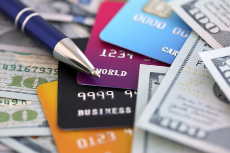 One hundred US dollar bills and silver pen with credit cards close up. Concept of business...