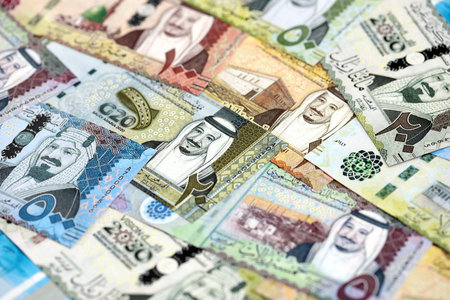 Saudi Arabia riyal money bills banknotes lies in big pile on table close up. Concept of finances and...