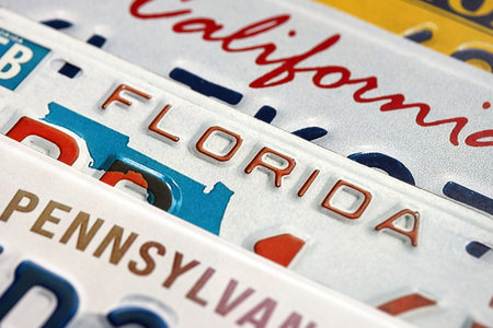 Old US car license plates with various state names close up. Concept of driving in United States....