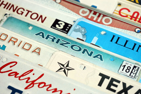 Old US car license plates with various state names. Concept of driving in United States. Reaching a car registrationの写真素材