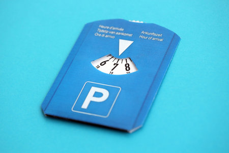 Parking disc for windshield. Limited time parking system in european countries. Concept of parking time count in busy parking lotsの写真素材