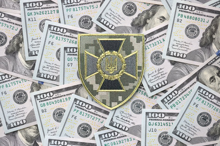 KYIV, UKRAINE - OCTOBER 7, 2025 State Border Guard Service of Ukraine patch on many US dollar bills close upのeditorial素材