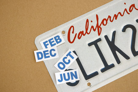 KYIV, UKRAINE - OCTOBER 1, 2025 Many California car registration month tag stickers on license plate close upのeditorial素材