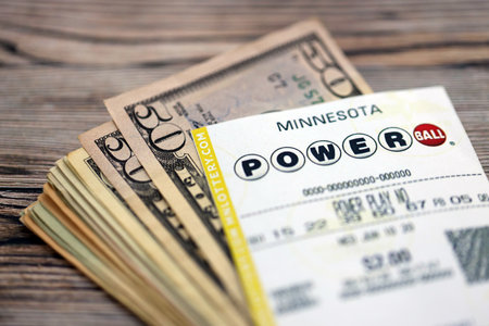 KYIV, UKRAINE - OCTOBER 22, 2025 Power Ball lottery ticket lies with money on wooden table close upのeditorial素材