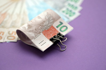 Close up of brazilian reais money bills in big amount on purple table. Pile of Brazil real currency banknotes. Finance and banking conceptの写真素材