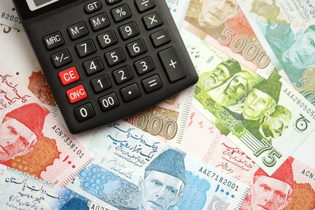 Pakistan rupees banknotes and calculator. The current Pakistan money bills and calculator lies on table in big amount. The concept of taxation and money count in Pakistanの写真素材
