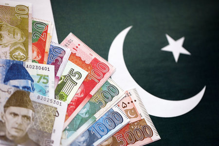 Pakistan rupees banknotes on Pakistani flag background. The current Pakistan money bills lies on banner in big amount. The concept of economics and business in Pakistanの写真素材
