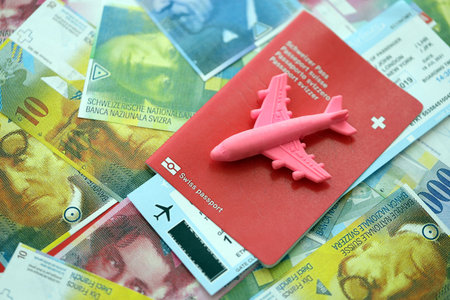 Swiss franc banknotes and passport with tickets. The current francs money bills and biometrical pass lies on table in big amount. The concept of travel and vacation in Switzerlandの写真素材