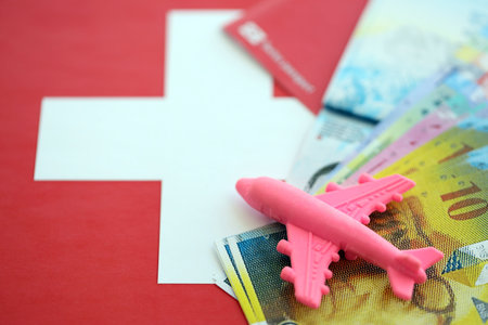 Swiss franc banknotes and passport with tickets on flag. The current francs money bills and biometrical pass lies on flag. The concept of travel and vacation in Switzerlandの写真素材