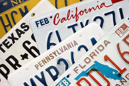 Old US car license plates with various state names close up. Concept of driving in United States. Reaching a car registrationの写真素材