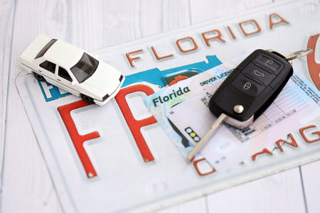 Remote control car keys on Florida license plate with driver license. Concept of driving in Florida. Reaching a driving permitの写真素材