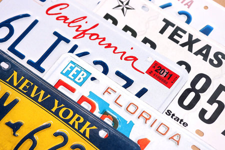 Old US car license plates with various state names close up. Concept of driving in United States. Reaching a car registrationの写真素材