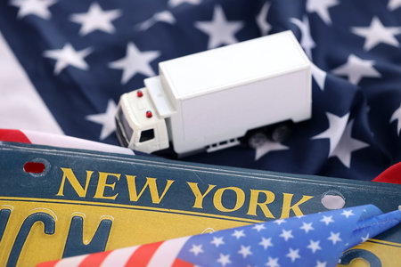 Toy truck and USA state of New York license plate on US flag. Concept of driving in New York. Reaching a driving permitの写真素材