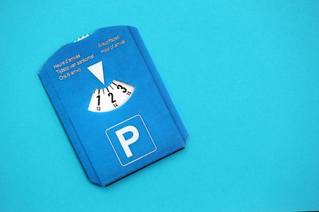 Parking disc for windshield. Limited time parking system in european countries. Concept of parking time count in busy parking lotsの写真素材
