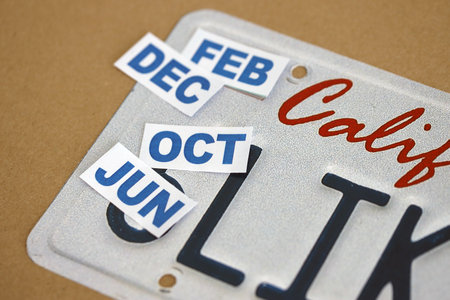 KYIV, UKRAINE - OCTOBER 1, 2025 Many California car registration month tag stickers on license plate close upのeditorial素材