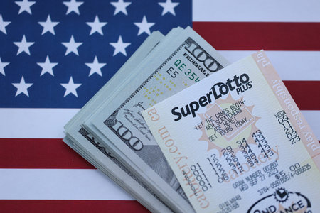 KYIV, UKRAINE - OCTOBER 22, 2025 Super Lotto lottery ticket lies on dollar bills and US flag close upのeditorial素材