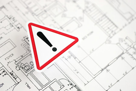 KYIV, UKRAINE - OCTOBER 3, 2025 Exclamation sign on white blueprints for construction close upのeditorial素材