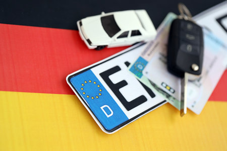 Germany Deutschland car license plate and ignition key on german flag close up. Driving permit and registration conceptの写真素材