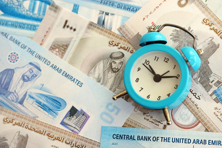 United Arab Emirates dirham currency money bills and alarm clock close up. The concept of time...