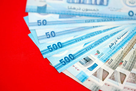 United Arab Emirates dirham money bills in big amount close up on red. Finance and banking conceptの写真素材