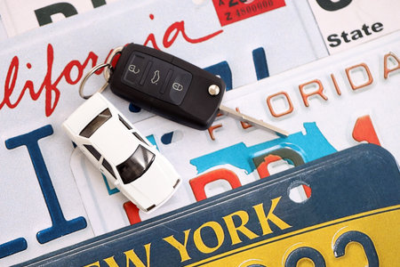 Remote control car keys on US license plates with state names close up. Concept of driving in United States. Reaching a car registrationの写真素材