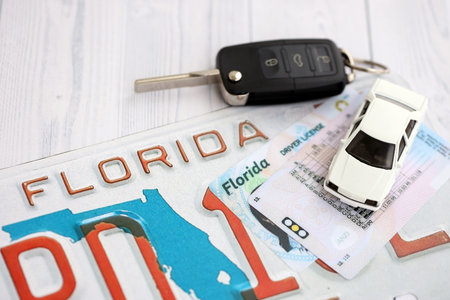 Remote control car keys on Florida license plate with driver license. Concept of driving in Florida. Reaching a driving permitの写真素材