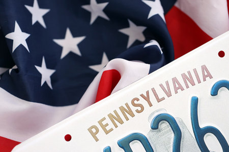 USA state of Pennsylvania license plate on US flag. Concept of driving in Pennsylvania. Reaching a driving permitの写真素材