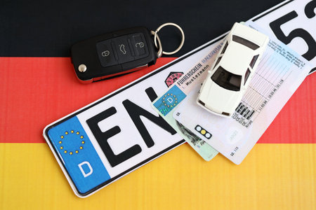 Germany Deutschland car license plate and ignition key on german flag close up. Driving permit and registration conceptの写真素材