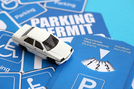 Parking permit paper notice tag and parking disc with toy car. Parking permit for people with...